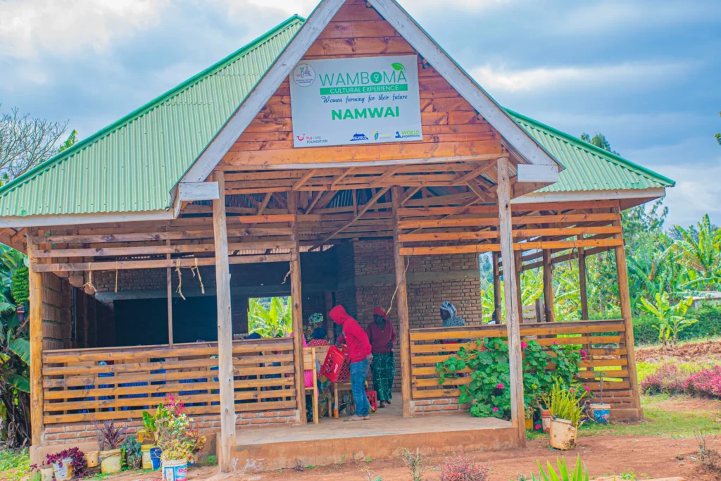 The Wamboma Cultural Experience cooperative building, its signboard reading “Women farming for their future”
